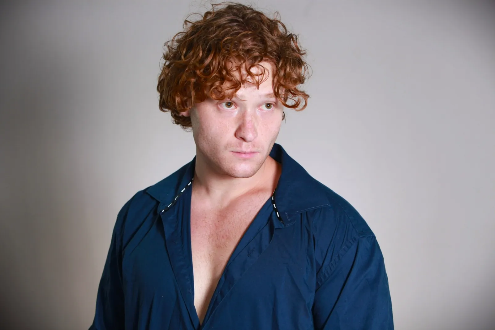 Three-quarter theatrical headshot in a blue shirt