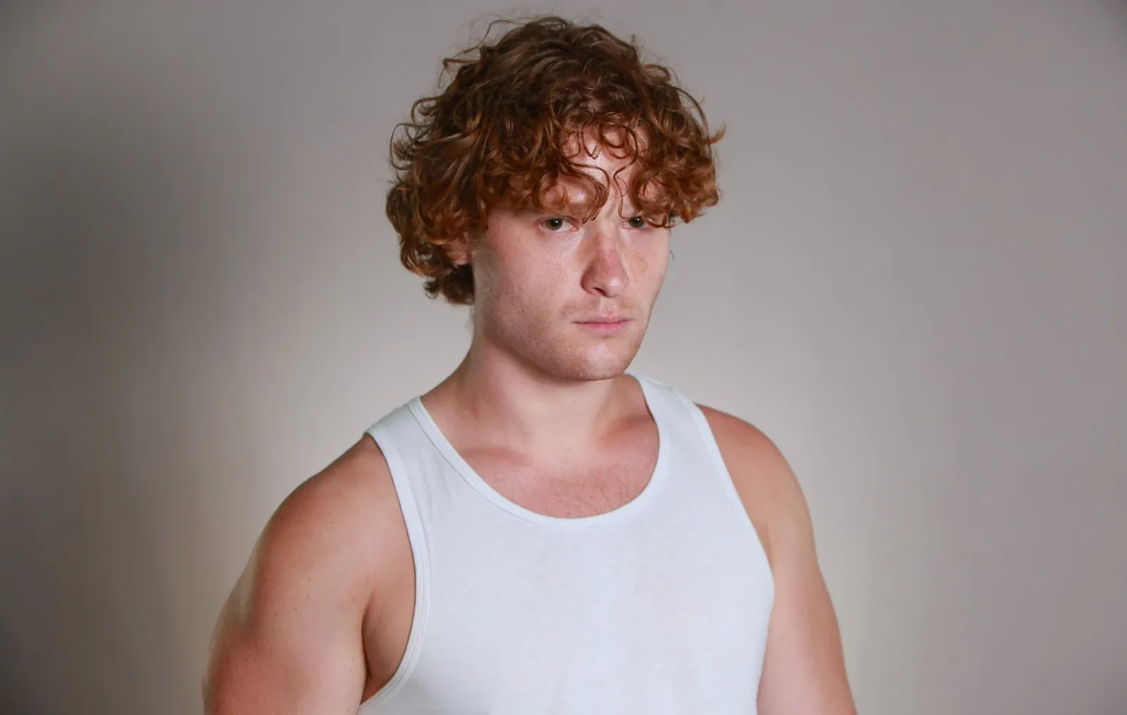Character headshot in a white tank top